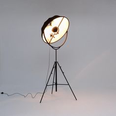 a light that is on top of a tripod in front of a white wall