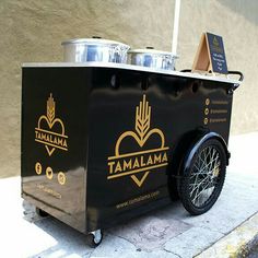 an ice cream cart is parked on the side of the street with two cups in it