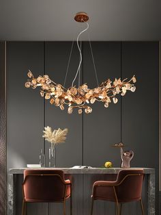 an elegant chandelier hangs over a dining room table with two chairs and a vase