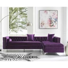 a living room with a purple couch and zebra rug