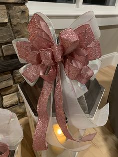 a large pink bow on top of a candle holder