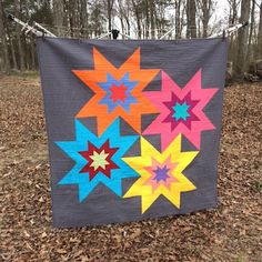 a quilt hanging on a clothes line in the woods