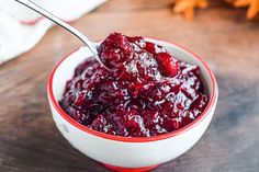 a bowl filled with cranberry sauce on top of a wooden table