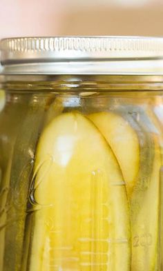 a jar filled with pickles sitting on top of a table