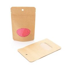 a brown paper bag with a pink sticker on it and a piece of cardboard next to it