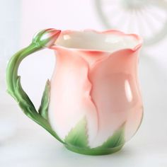 a pink and green vase sitting on top of a table