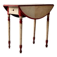 an old red and white wooden table with two drawers on one side, turned upside down