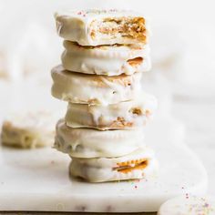 a stack of doughnuts with white frosting and sprinkles