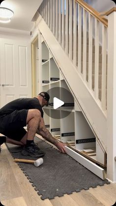 a man kneeling on the ground in front of a stair case with an open door