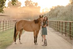 a woman standing next to a brown horse