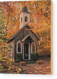 a small wooden church surrounded by trees in the fall