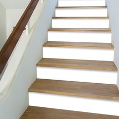 a set of wooden stairs leading up to a second story room with white walls and wood handrails