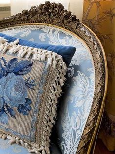 a blue and white chair with a decorative pillow on it