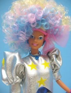 a barbie doll with blonde hair and stars on it's head wearing a silver dress