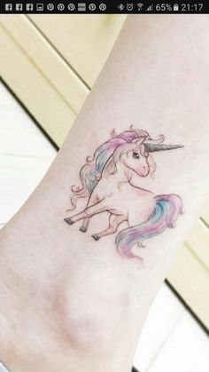 a small tattoo of a unicorn on the ankle, with pink hair and blue eyes