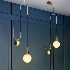 three lights are hanging from the ceiling in a room with blue walls and flooring