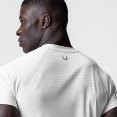 Lightweight hybrid training shirt in a slim fit. Constructed from our new 3D-Lite® 2.0 Lycra® material that integrates revolutionary Lycra® Spandex fibers, surpassing traditional elastics in strength and durability. The resulting garments are lighter, softer, and engineered for peak performance. Designed with the same fit and raglan sleeves as our bestselling Established Tee, but with a straight bottom hem for a streamlined aesthetic. Strategic perforation on the backside enhances airflow and br Technical Stretch T-shirt For Sports, Technical Breathable Fitted T-shirt, Technical Athletic Fit Short Sleeve T-shirt, Technical Breathable Athletic Fit T-shirt, Technical Stretch Breathable T-shirt, Train Kit, Gym Training, Peak Performance, Body Fit