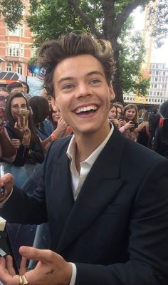 a man in a suit is taking a selfie with his cell phone and people behind him