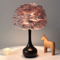 a small table with a lamp on it and a toy horse sitting next to it