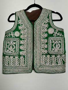 Made in Afghanistan, this a rare find vintage sleeveless waistcoat. Hand embroidery on velvet. A very antique piece in mint condition.  Measurements in inches (flat):  Shoulder: 12 Bust: 18.5 Length: 20 Note: Worn and minor signs of wear. Festive Vest With Intricate Embroidery, Festive Sleeveless Vest With Intricate Embroidery, Sleeveless Embroidered Vest For Festive Occasions, Festive Bohemian Sleeveless Vest, Vintage Embroidered Fitted Vest, Fitted Vintage Vest With Embroidery, Bohemian Sleeveless Vest For Festivals, Vintage Fitted Embroidered Vest, Festive Embroidered Sleeveless Vest