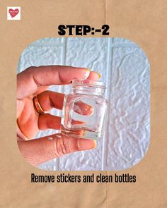 a person holding a small jar filled with water and text that reads, step - 2 remove stickers and clean bottles