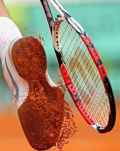 the tennis racket is being held up by someone's hand with powder on it