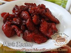 a white plate topped with meat covered in sauce