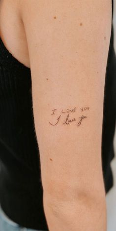 a woman with a tattoo on her arm that says i love you