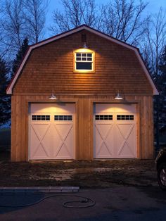 two garages are lit up at night with lights on the top and bottom doors