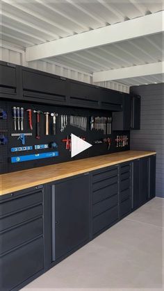 an organized garage with lots of tools on the wall and cabinets in front of it