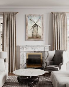 a living room filled with furniture and a fire place in front of a painting on the wall