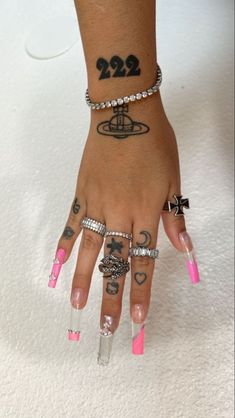 a person with tattoos on their hands and fingers, holding onto two different bracelets