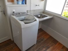 a washer and dryer sitting in a small room next to a window on the wall