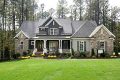 a house in the woods with lots of trees and grass on the front lawns