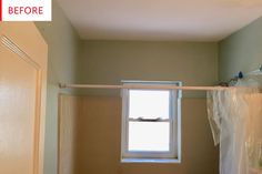 an empty bathroom with a window and shower curtain