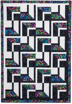 a black and white quilt with multicolored flowers on the border is shown in this image