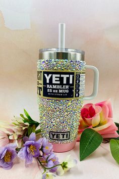 the yeti tumbler is next to some flowers