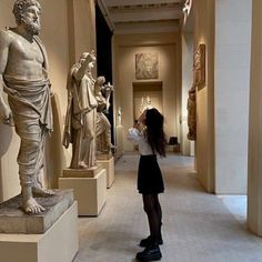 a woman standing in front of some statues