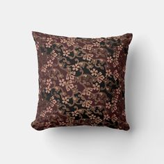 a brown and black floral pillow on a white wall with the back side of it