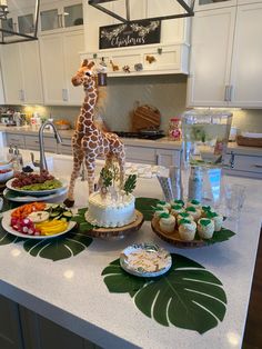 a giraffe figurine standing on top of a counter next to plates of food