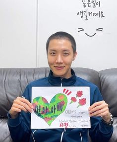 a man sitting on a couch holding up a sign