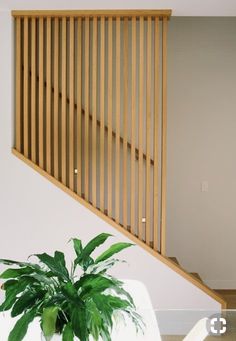 a potted plant sitting on top of a table next to a wooden stair case