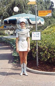 a woman standing in front of a street sign with an astronaut costume on her head