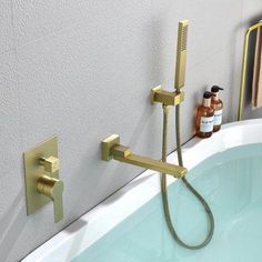 a bathtub with a shower head and hand held faucet next to it