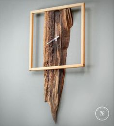 a clock made out of wood is mounted to the wall in a frame with an arrow on it