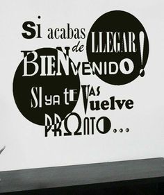 a man sitting at a desk in front of a wall with the words'si acabs de legar benvenndo, sla et lat va