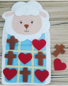 a sheep with crosses and hearts is on the table next to some cut out cookies