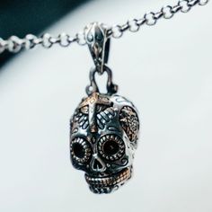 This tiny skull punches above its weight class! Unparalleled depth created by the contrast of jeweler's brass on silver. Sized perfectly for daily wear, the unisex design won't slow you down. Inspired by the ornate Mexican Day of the Dead skulls, master silversmiths pack unrivaled detail into each pendant. Each piece features bright brass surrounded by intricate carved embellishments. Pair it with a Calavera Sugar Skull ring to complete the look. Ready to make a statement? Sterling silver and br Skull Print Necklace For Halloween Gift, Symbolic Skull Shaped Jewelry For Gift, Unique Skull Jewelry For Gift, Adjustable Skull Jewelry In A Spiritual Style, Halloween Skull Jewelry With Engraving, Black Engraved Skull Jewelry, Skull Shaped Engraved Necklaces For Gifts, Black Skull Shaped Engraved Jewelry, Spiritual Engraved Skull Jewelry