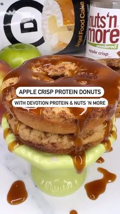 a stack of doughnuts with caramel drizzled on them and an apple in the background