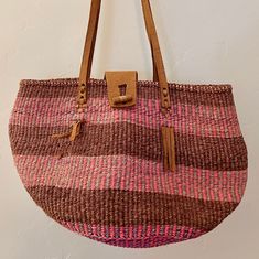 Vintage pink, purple and maroon jute bag with leather straps and fringe. Also has a toggle closure. Brown Fringe Straw Bag For Travel, Brown Fringe Tote Beach Bag, Pink Straw Tote Bag With Leather Handles, Pink Straw Bag With Leather Handles For Shopping, Pink Bohemian Bucket Bag For Everyday Use, Rectangular Pink Bag With Fringe, Pink Bohemian Bucket Bag For Everyday, Purple Shoulder Bag With Braided Handles For Shopping, Pink Woven Satchel Bag